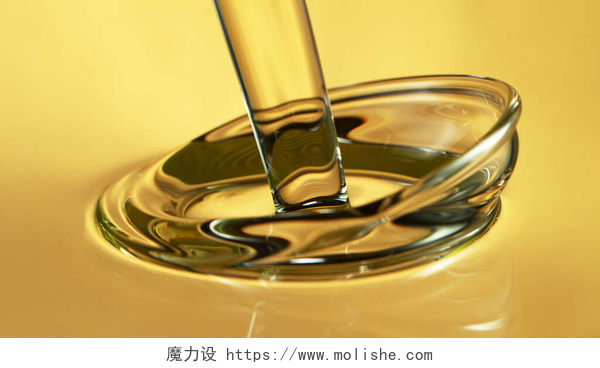 黄色背景中的液体油或水Freeze motion of pouring oil